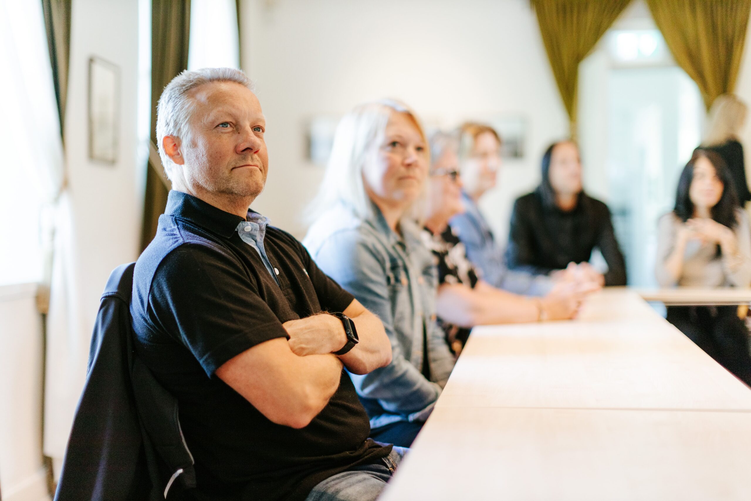 Deltagare samlade vid ett bord under Gruvstigarens konferens, med fokus på engagemang och diskussion i en ljus lokal.