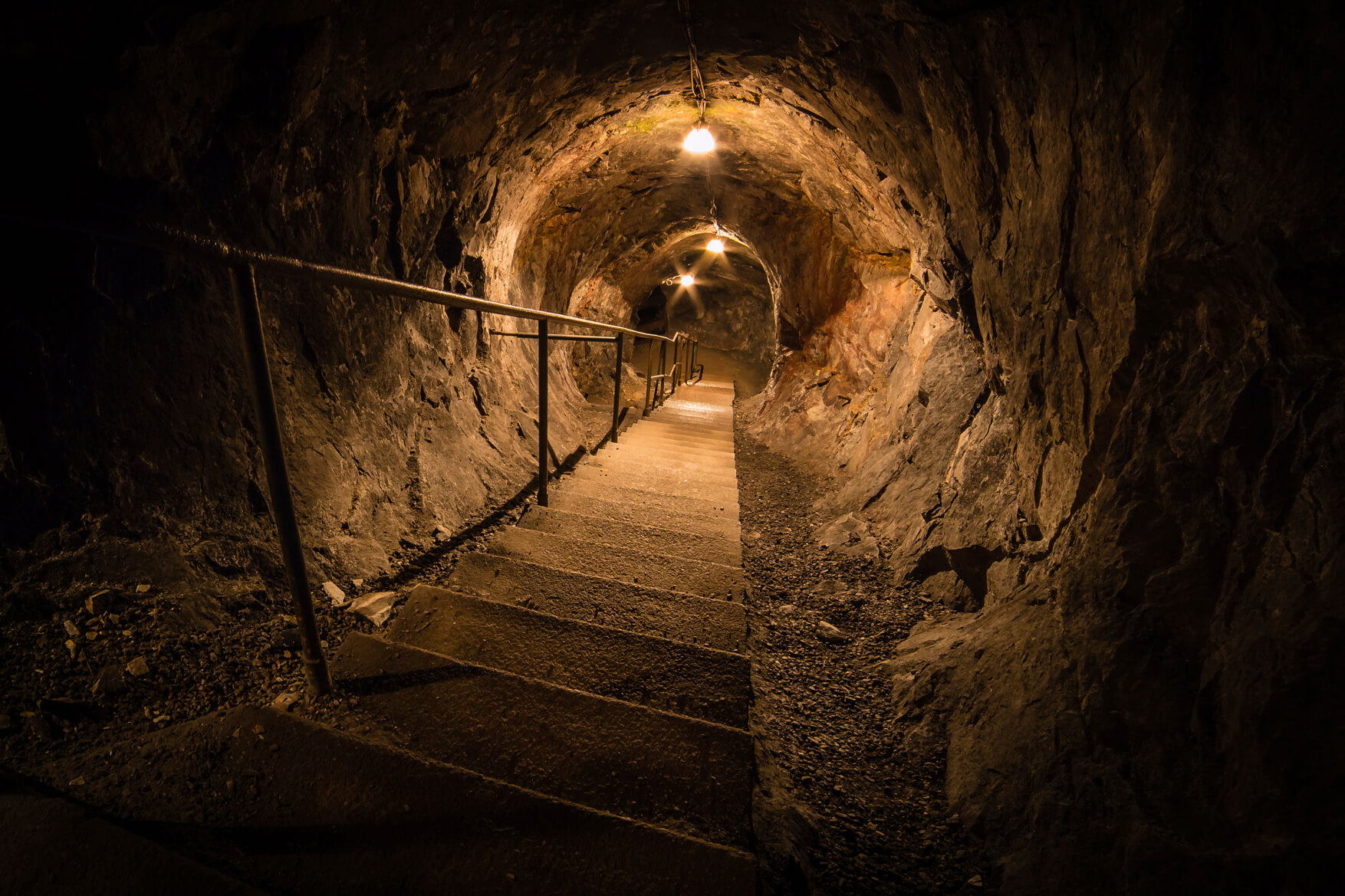 Underground mine tunnel at Sala Silvergruva with illuminated lanterns and a walkway through the rock