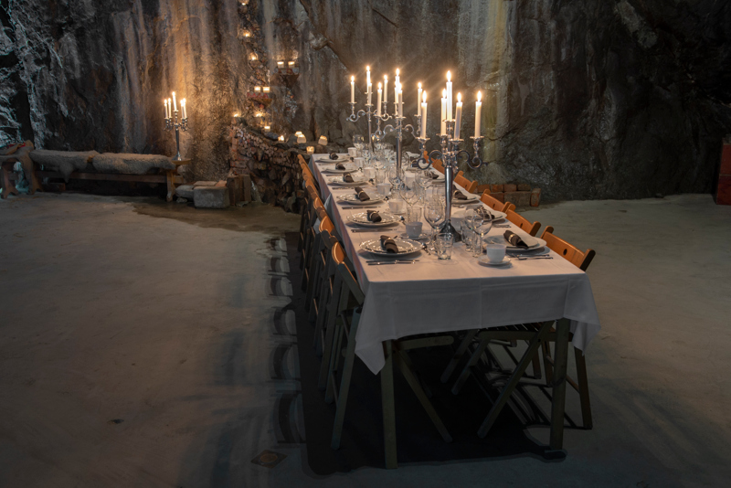 Eleganta dukade middagsbord i Victoriasalen, beläget 155 meter under jord, i Sala Silvergruva, med levande ljus och stämningsfull miljö.