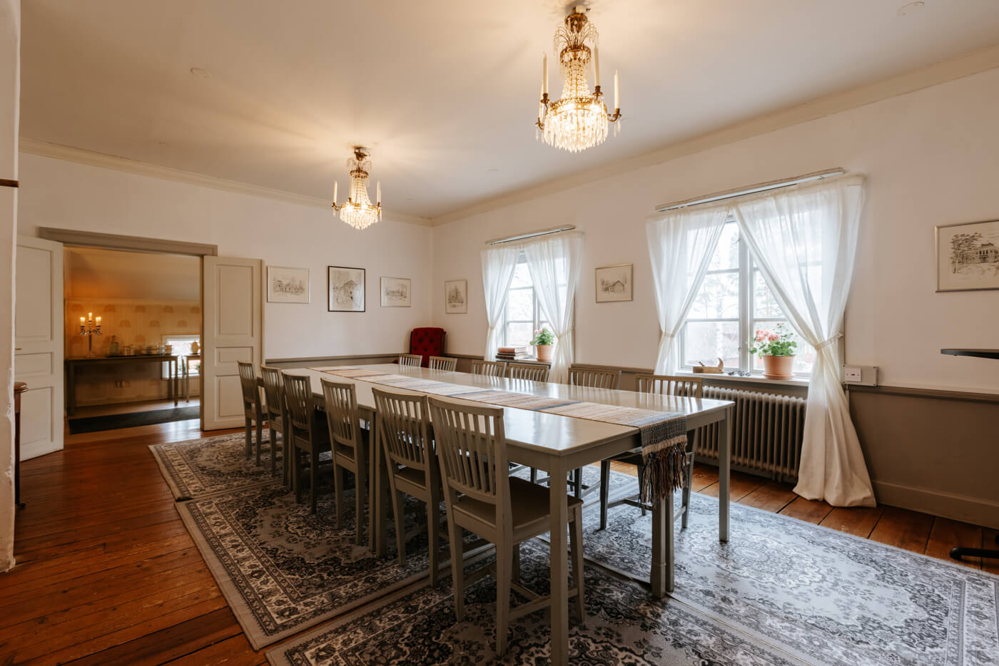 Ljust konferensrum med eleganta detaljer, lång bord, stolar och stora fönster som släpper in naturligt ljus.