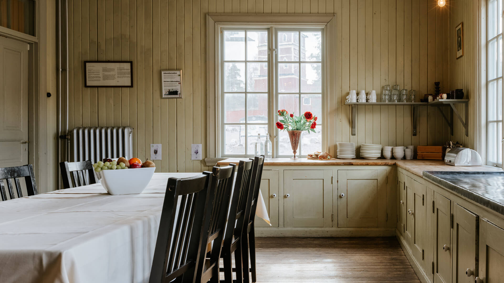 Ljust och inbjudande rum med lång matbord, stolar och en vas med blommor, idealiskt för boende vid Sala Silvergruva.