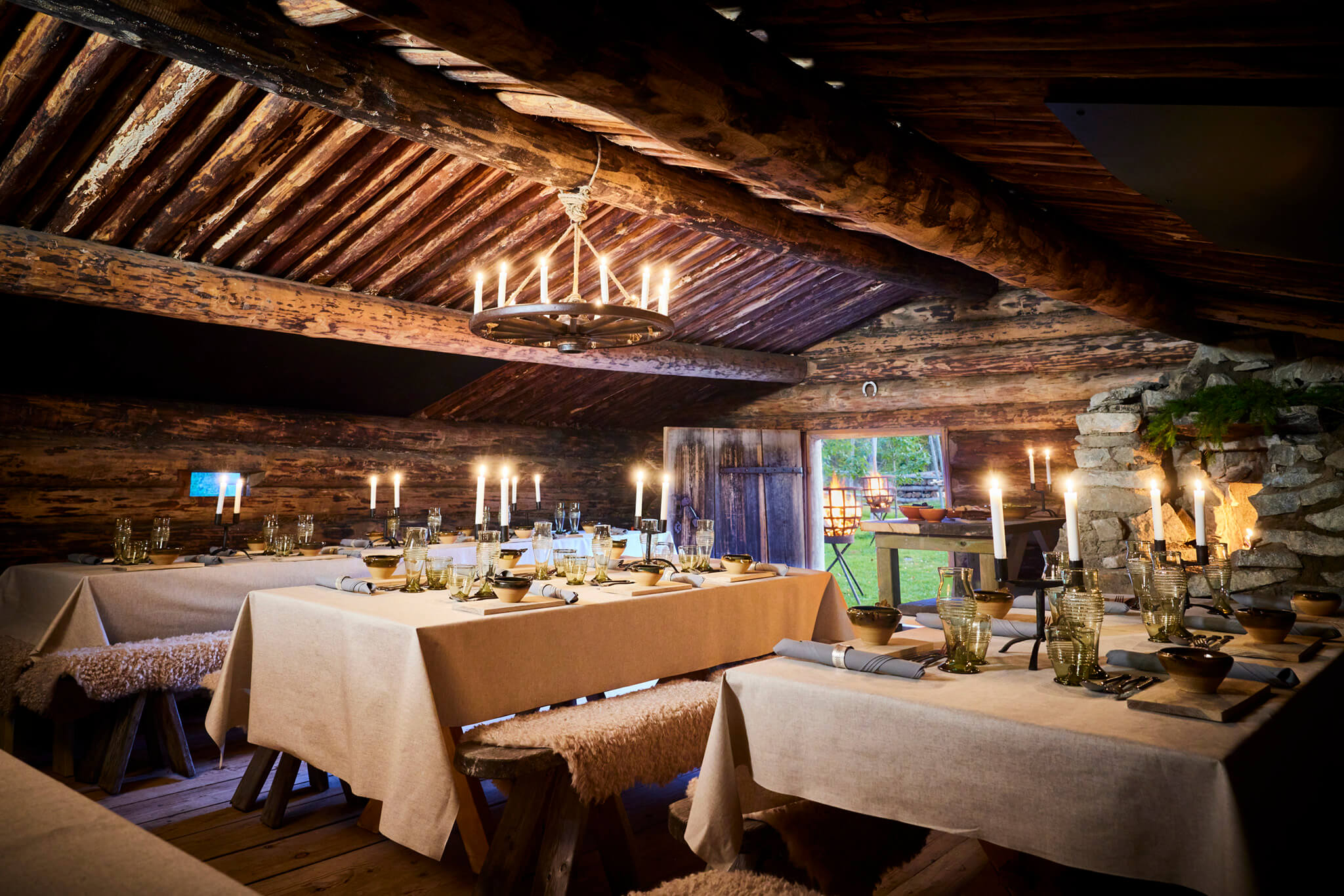 En mysig och varm restaurangmiljö med dukade bord, ljuskronor och dekorationer i trä nära Sala Silvergruva.