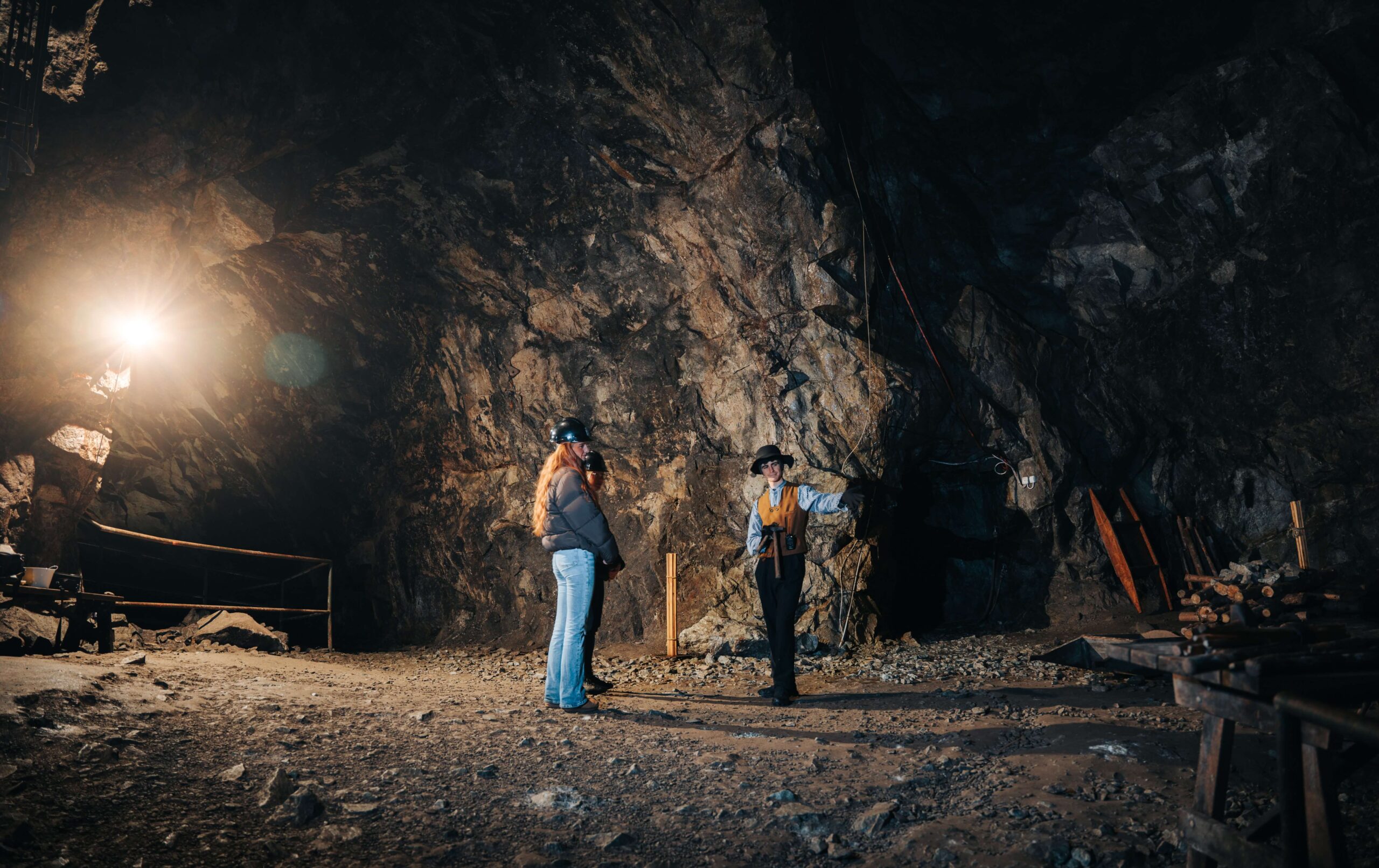 Besökare i Sala Silvergruva utforskar gruvans inre, med ljus som strålar mot de storslagna bergväggarna.